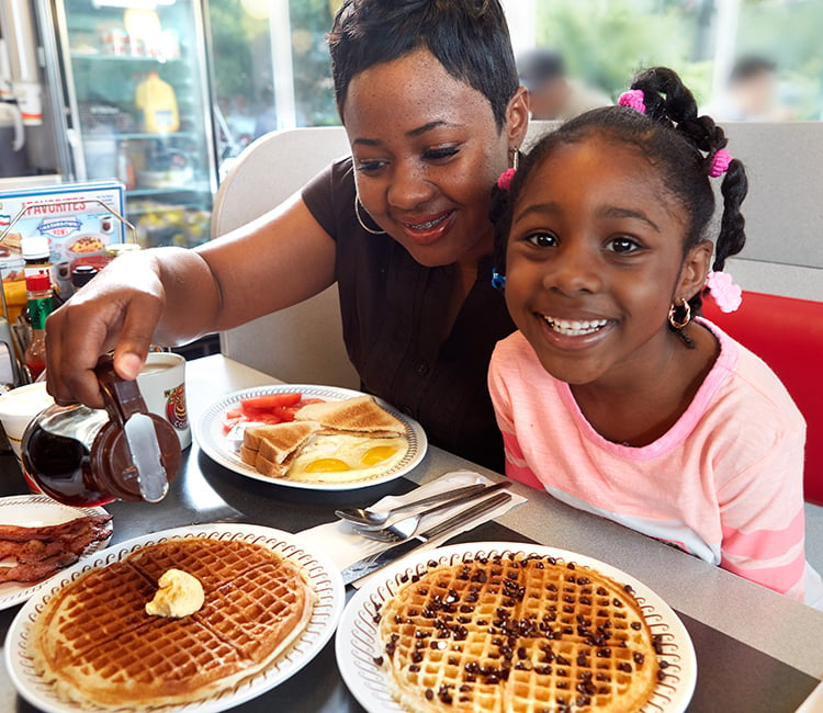 Mother and daughter enjoying a waffle house breakfast