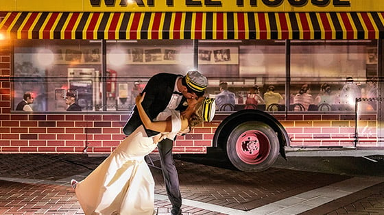 Groom kissing bride in front of Waffle House food truck