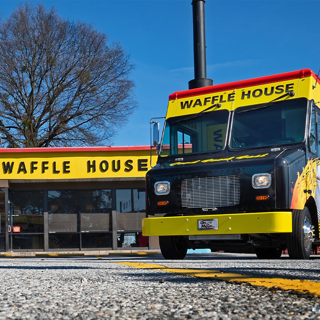 Two Waffle House food trucks with a unit in the background