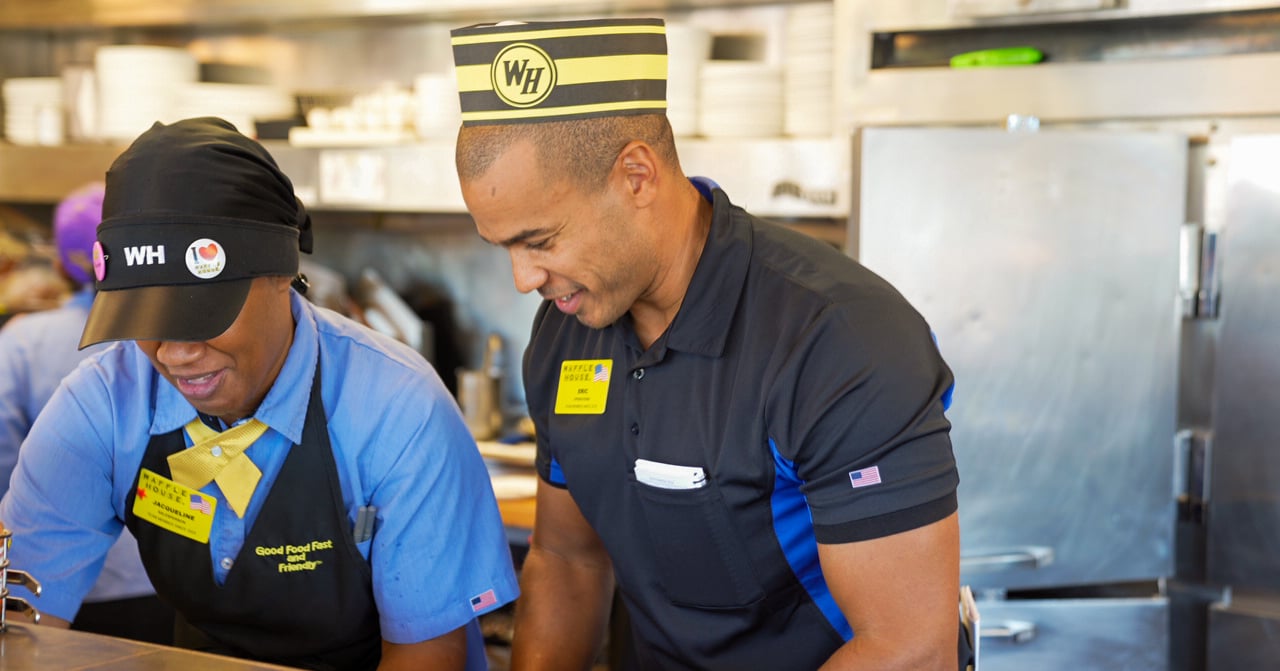 Manager engaged with an Associate in a teamwork motif